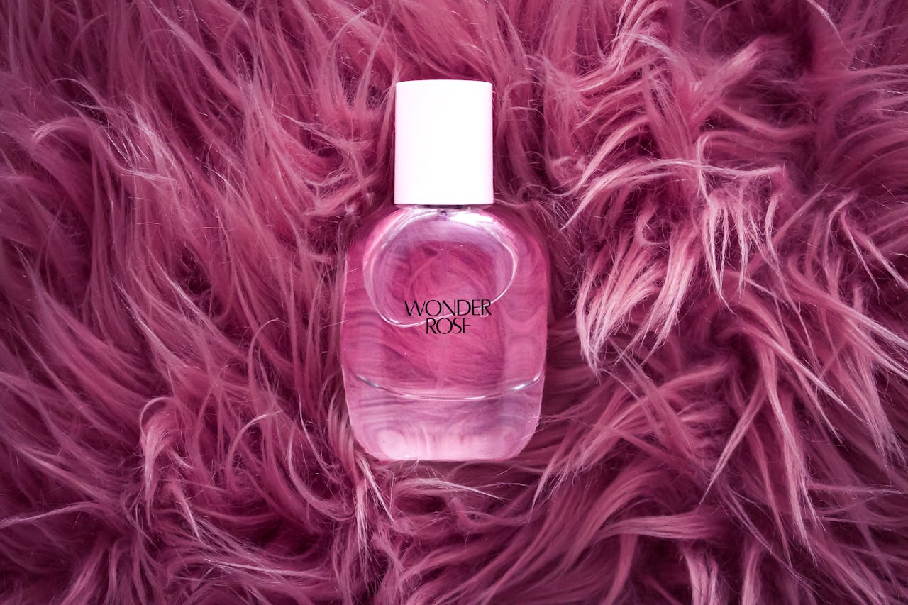 menu-01 A stylish pink perfume bottle on a plush, pink fur background, exuding elegance and luxury.